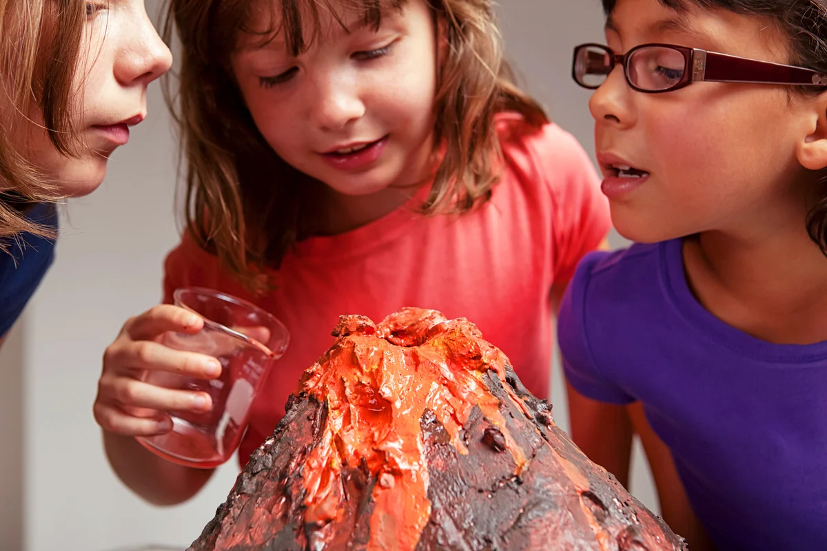 Little girls make their volcano science project erupt