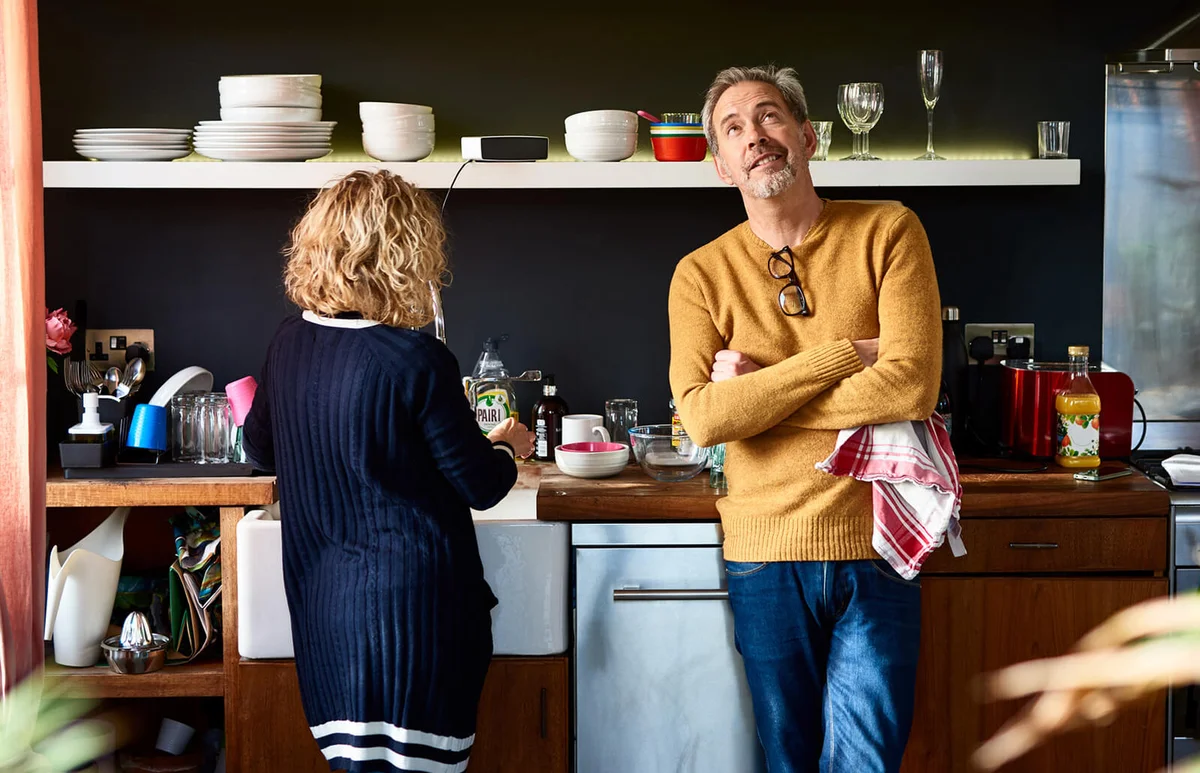 Mature man looking up with arms folded with wife