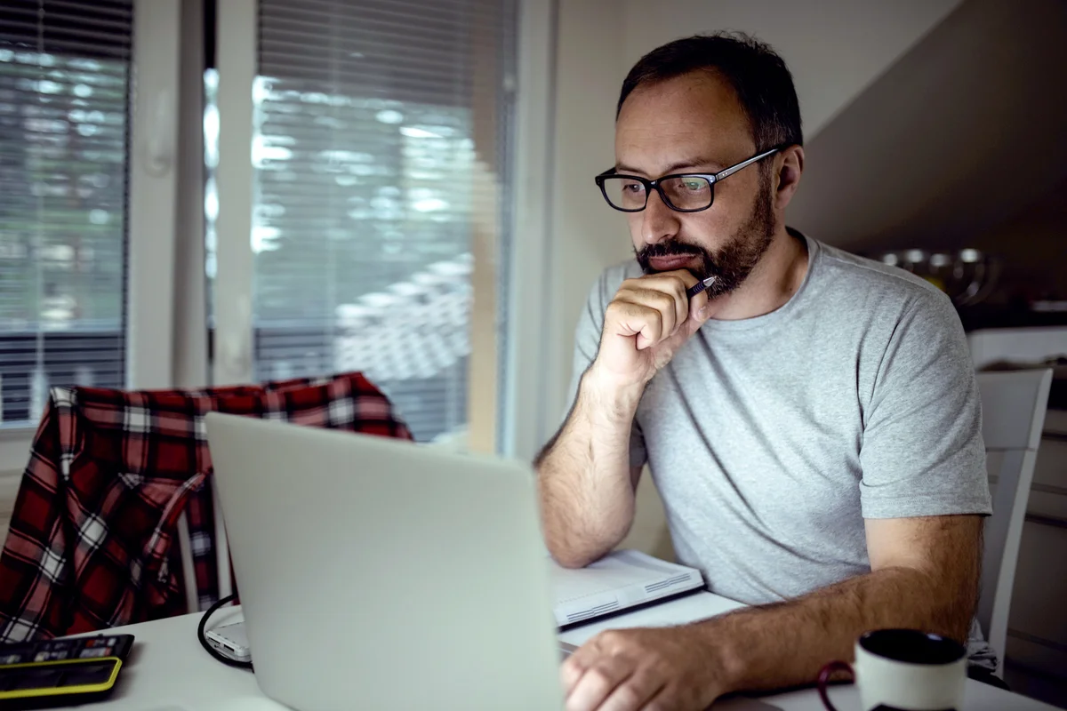 Sad man writing in the computer