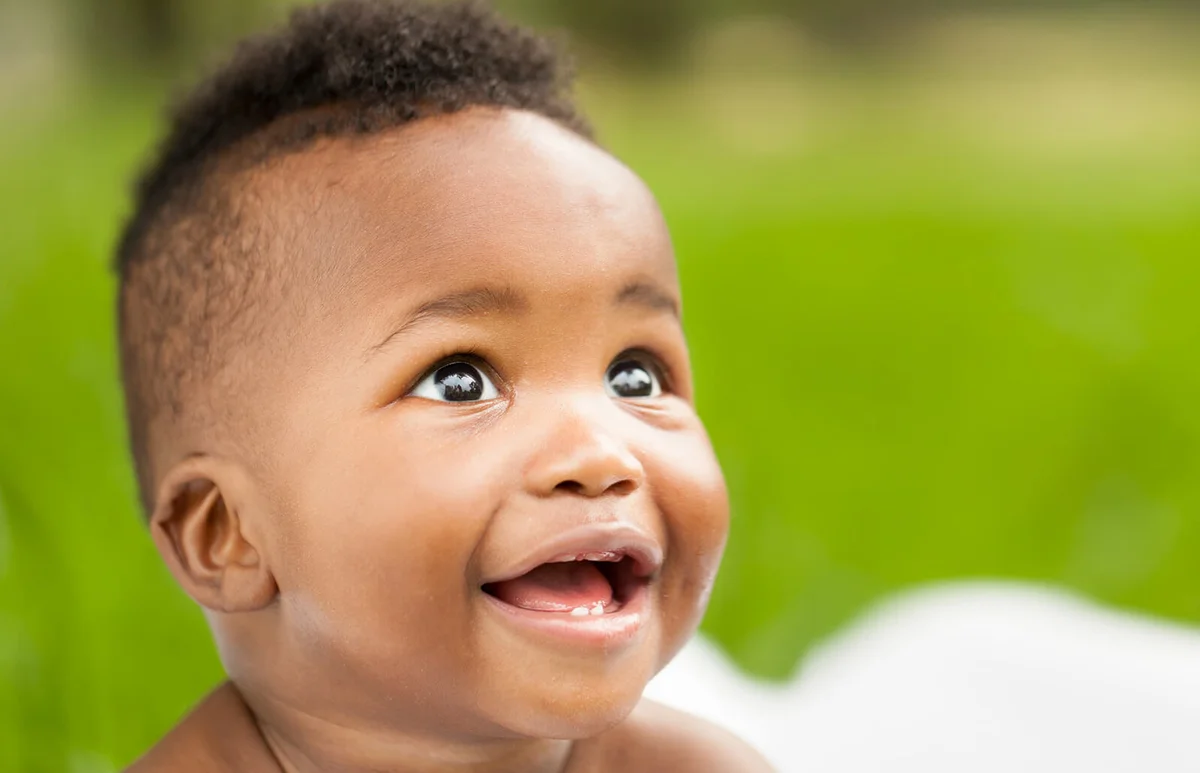 baby smiling while looking away.