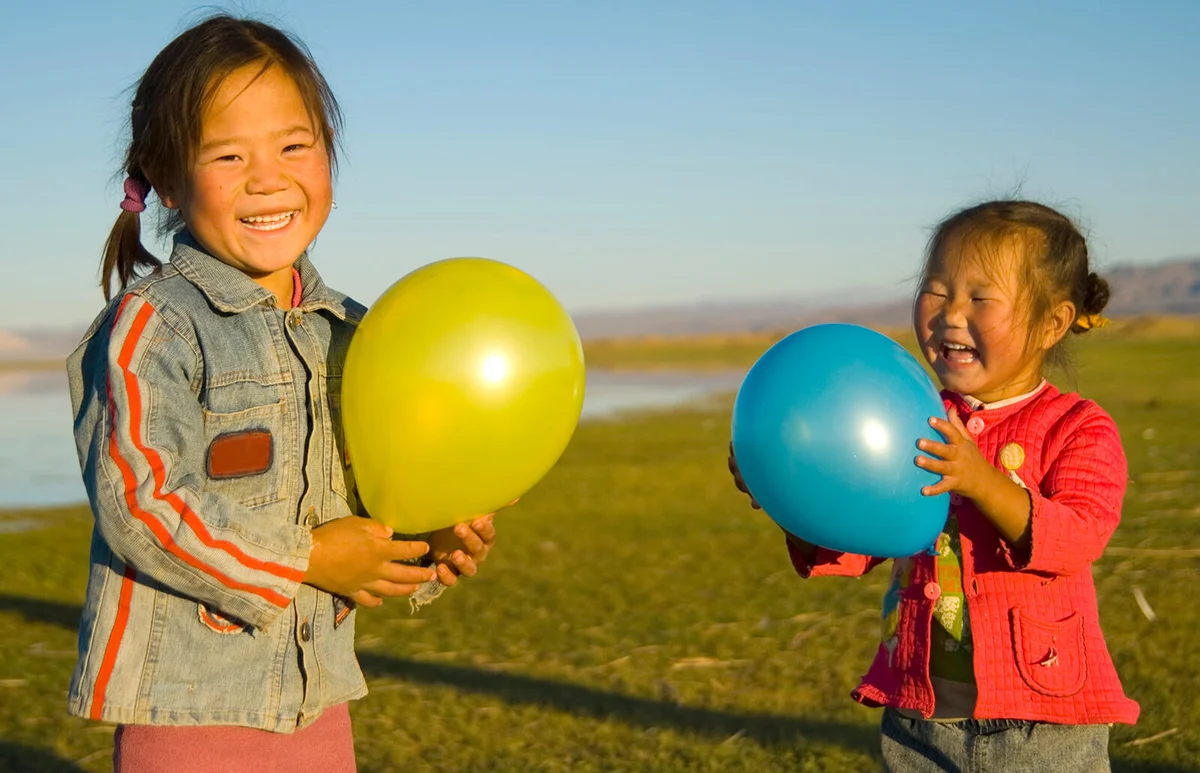 Little girls holing balloons in a field