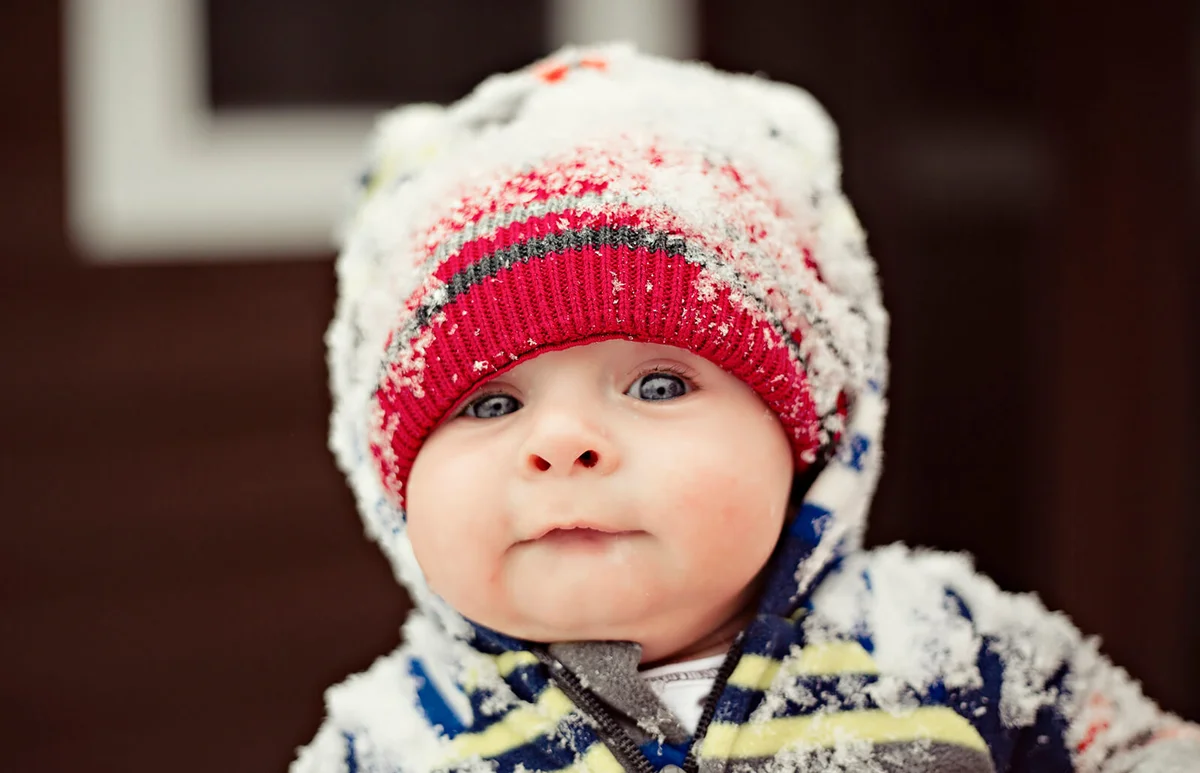 Baby wearing a hat under snow