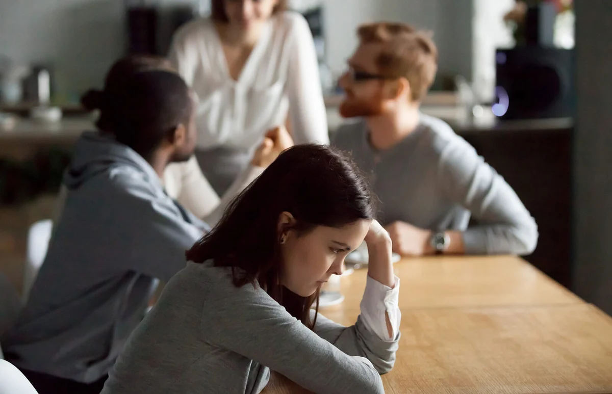 Sad frustrated girl feeling lonely suffering from discrimination among friends