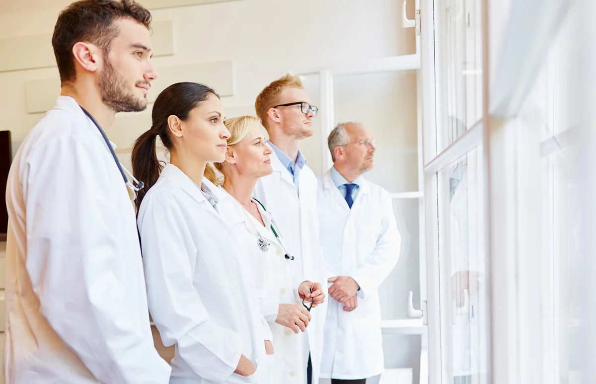 Doctors looking through window while standing in office