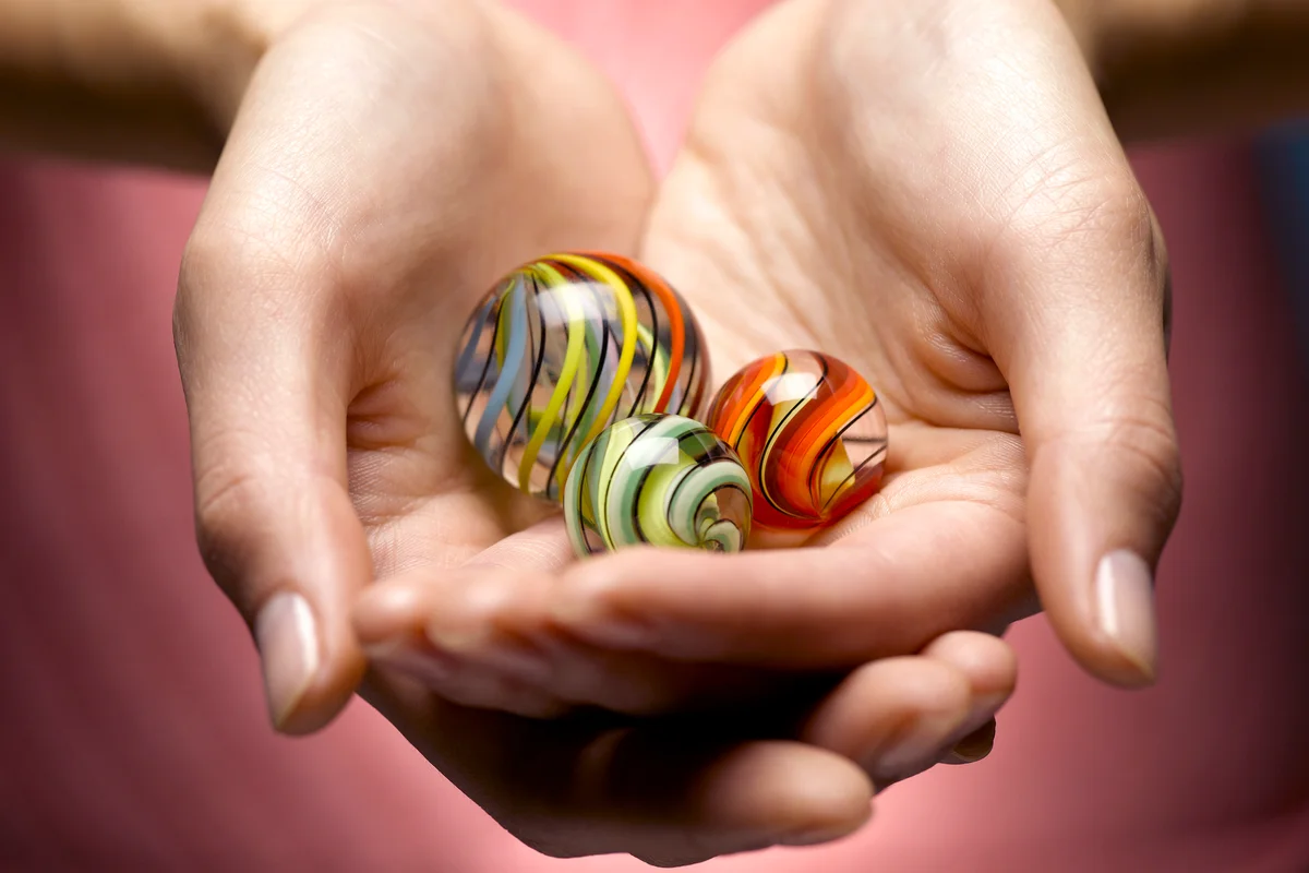 Young woman holding glass marbles in cupped hands