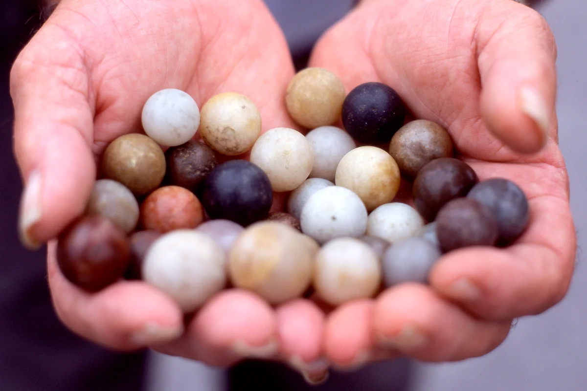 Hands Holding Flint Marbles