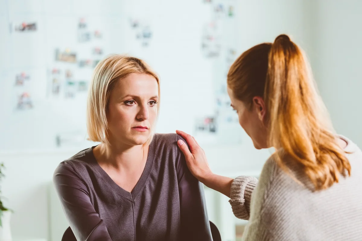 Woman talking to console her female friend