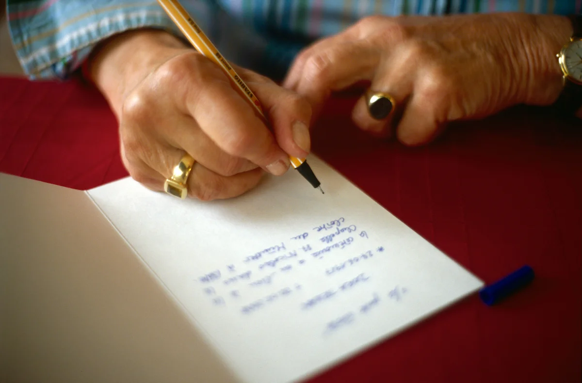 Woman writing personal message in sympathy card