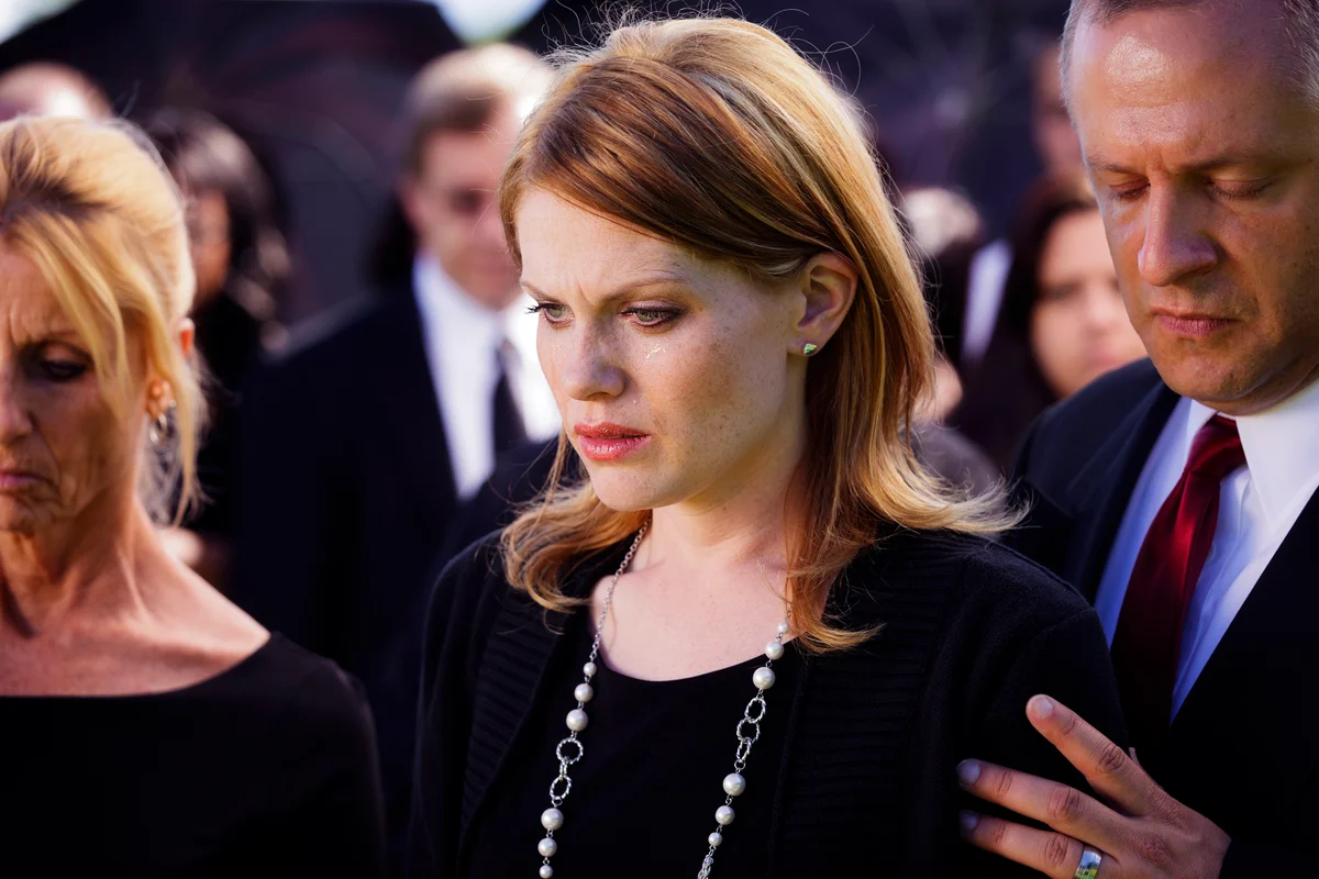 A grieving widow standing in a funeral