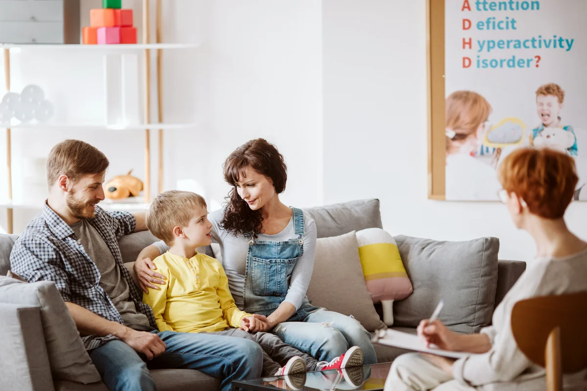 Caring parents and misbehaving boy during therapy session