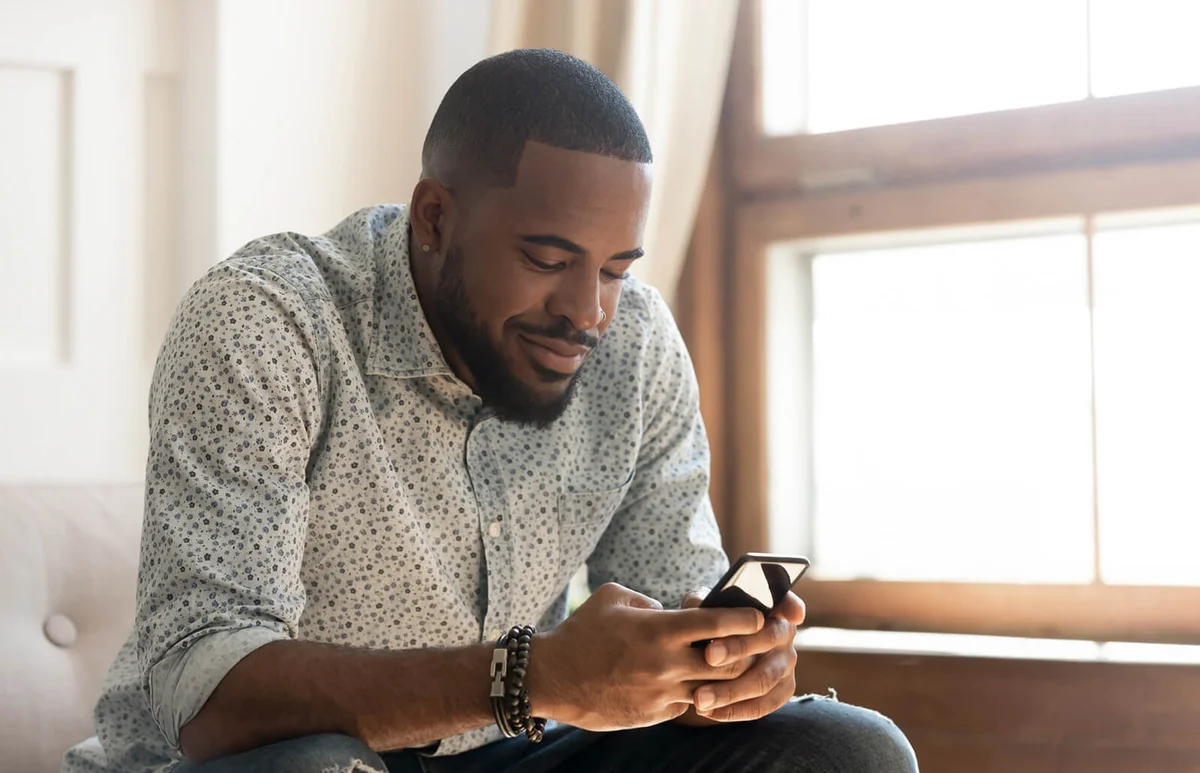 man using smartphone app sit on sofa