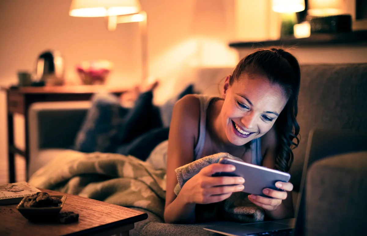 young woman using her phone at night