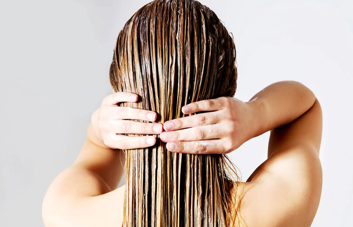 Woman applying conditioner on hair