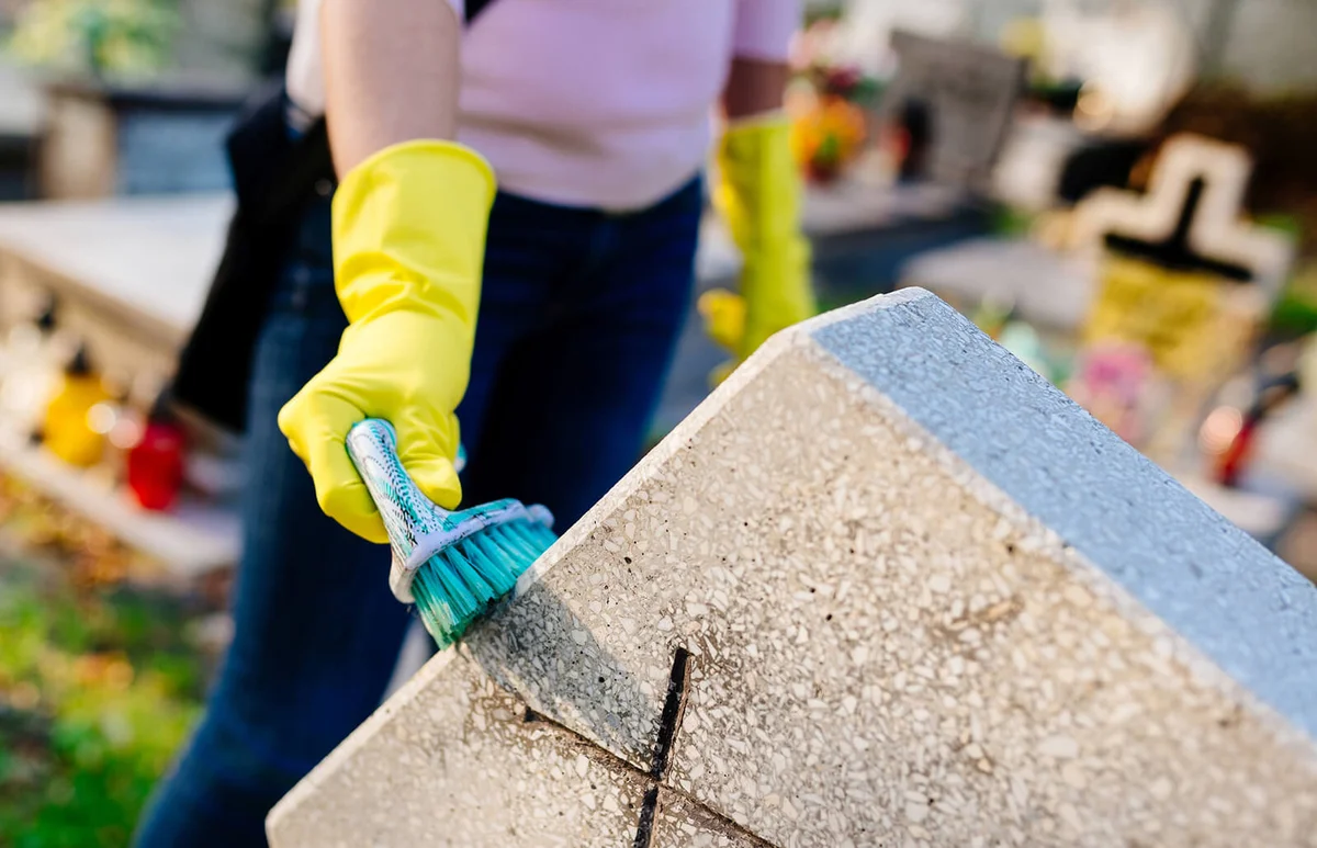 Washing tombstone with brush