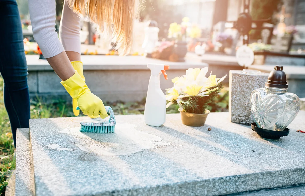 Washing tombstone with brush