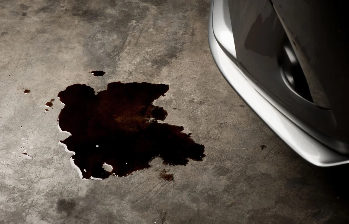 Oil leak or drop from engine of car on concrete floor