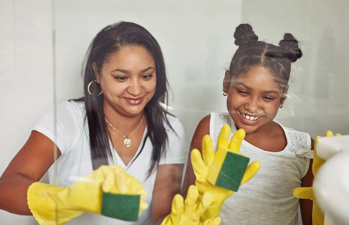 mother and her little daughter cleaning the bathroom together at home