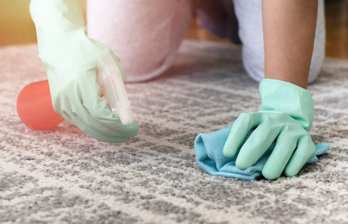 woman removing stain from the carpet