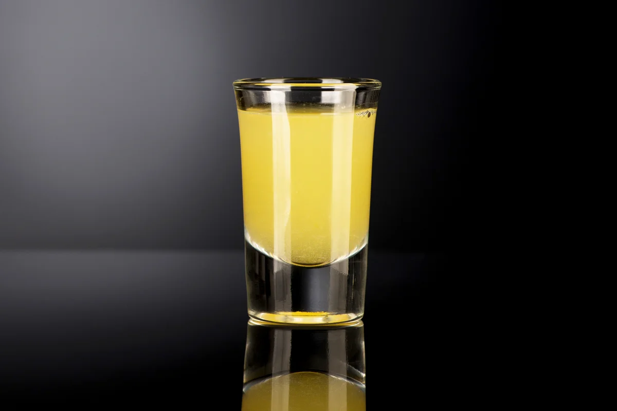 Shot glass with alcohol on a dark background