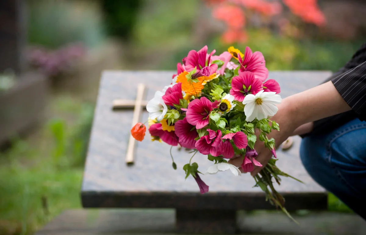 Woman leaving flowers at grave