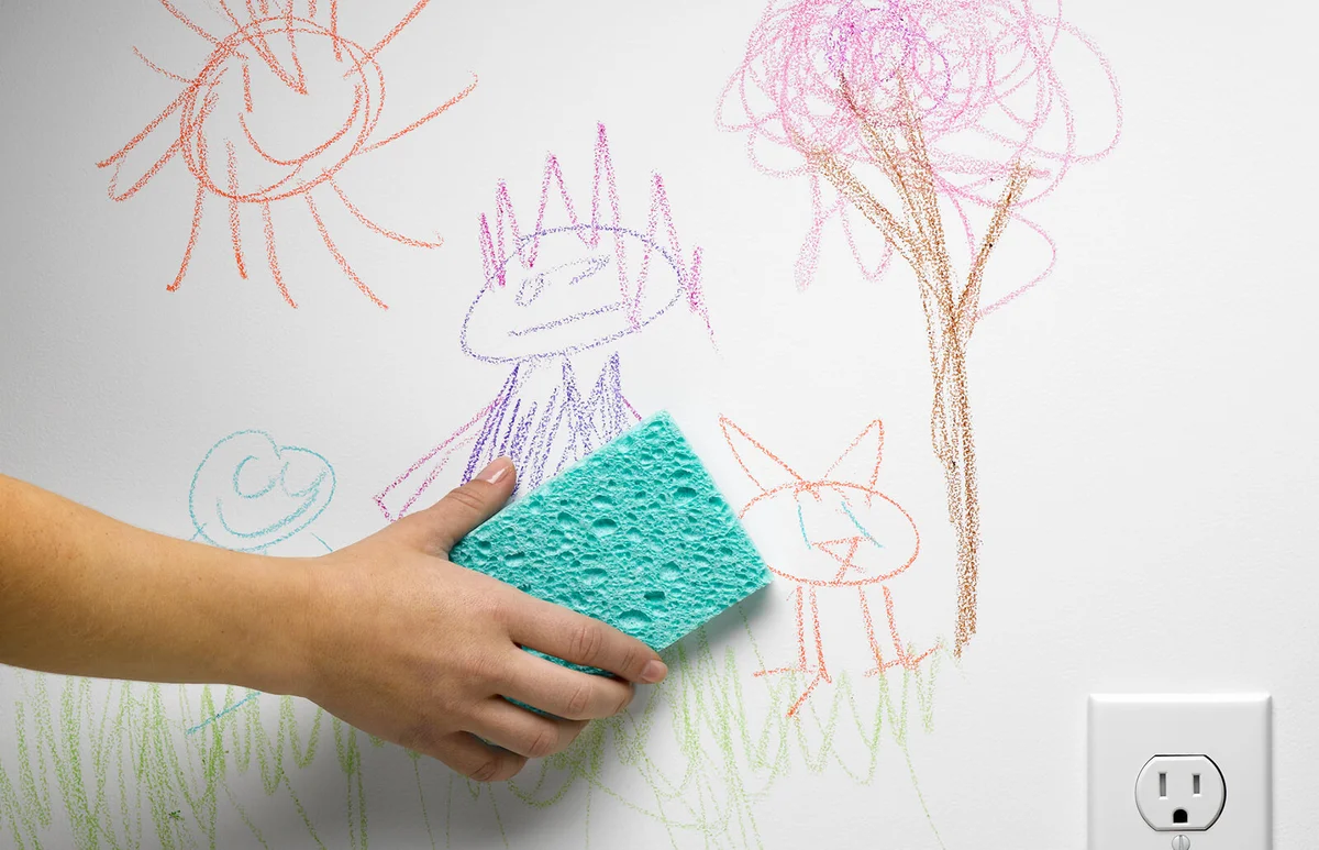Hand cleaning off child's drawing