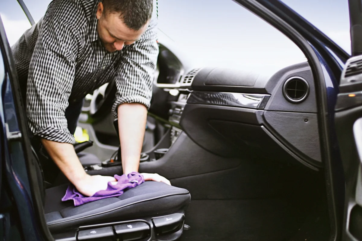 Man cleaning upholstery of his car