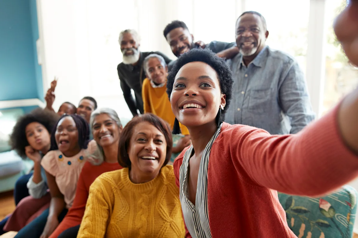 Smiling young woman taking selfie with family