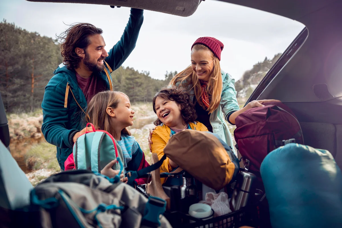 Young family getting the camping supplies out of the car