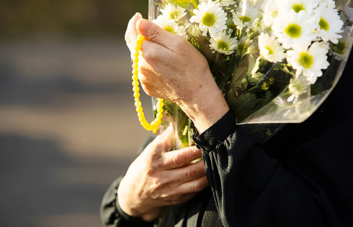 woman carrying flowers to memorial service
