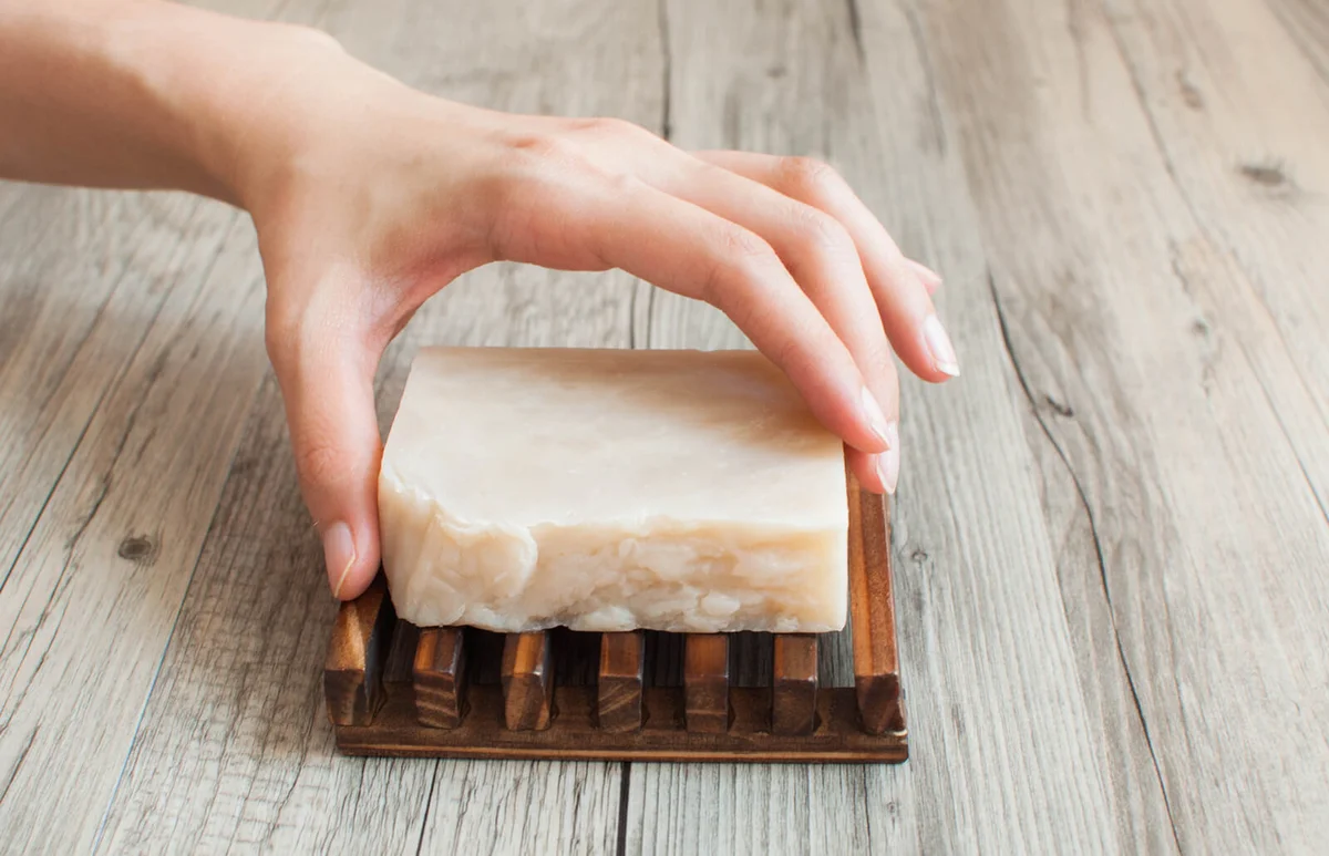 female hand holding a white organic soap