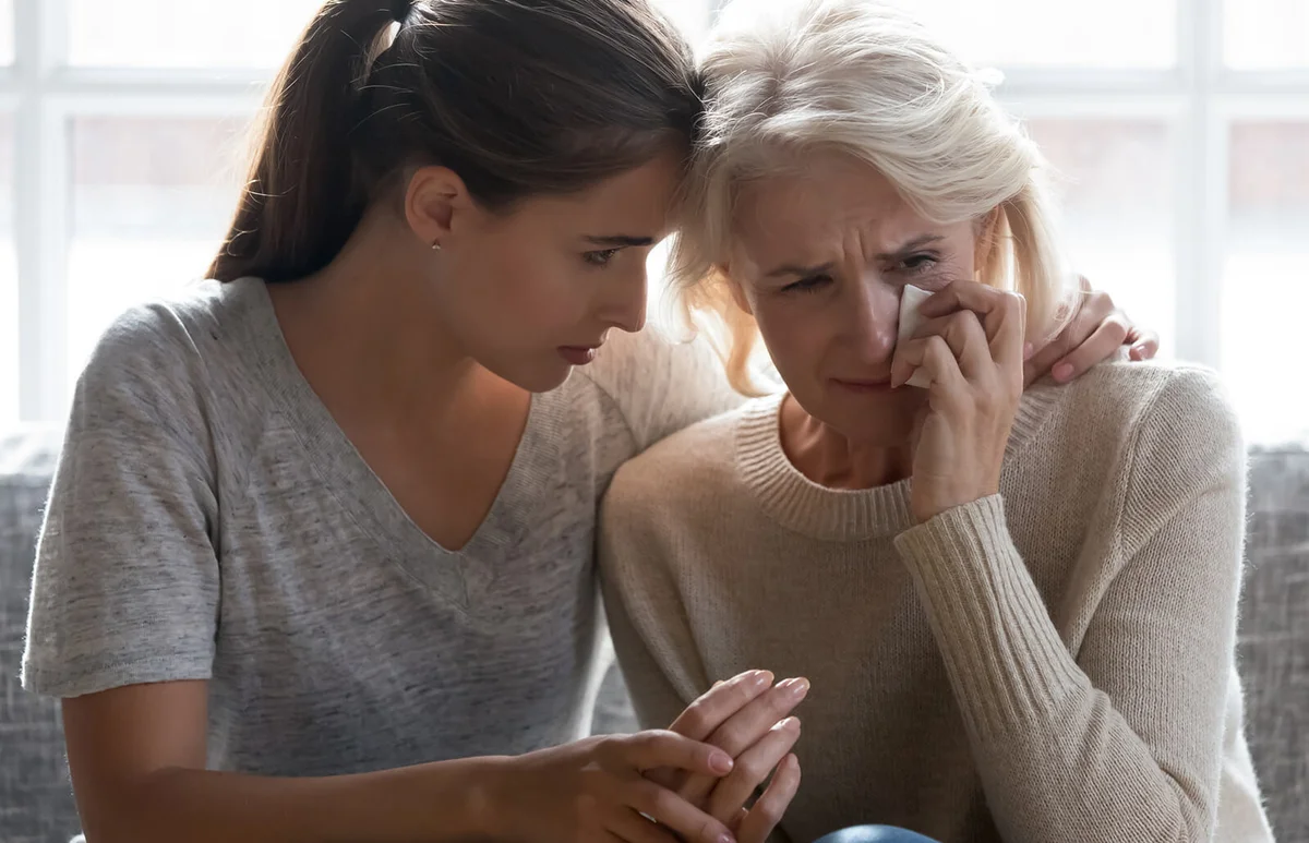 Daughter comforting grieving mom