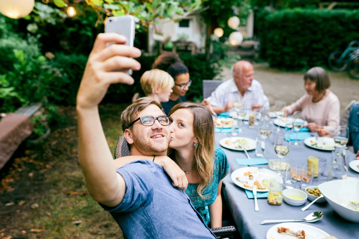 Couple Taking Selfie During BBQ With Family