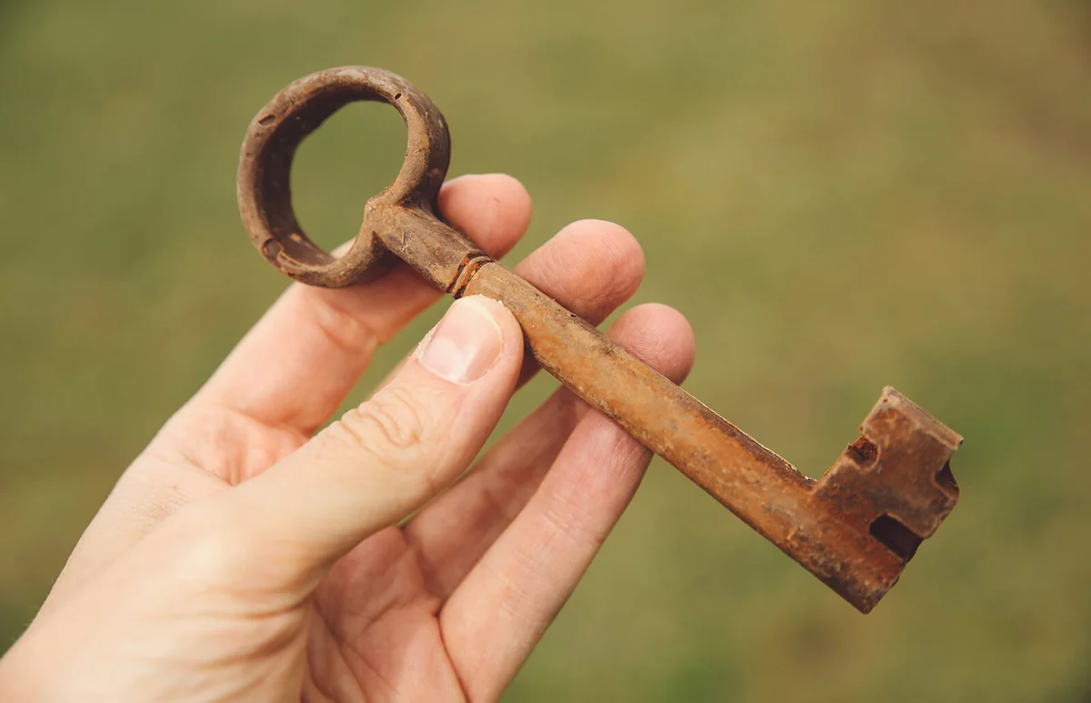 Person holding old-fashioned rusty metallic key