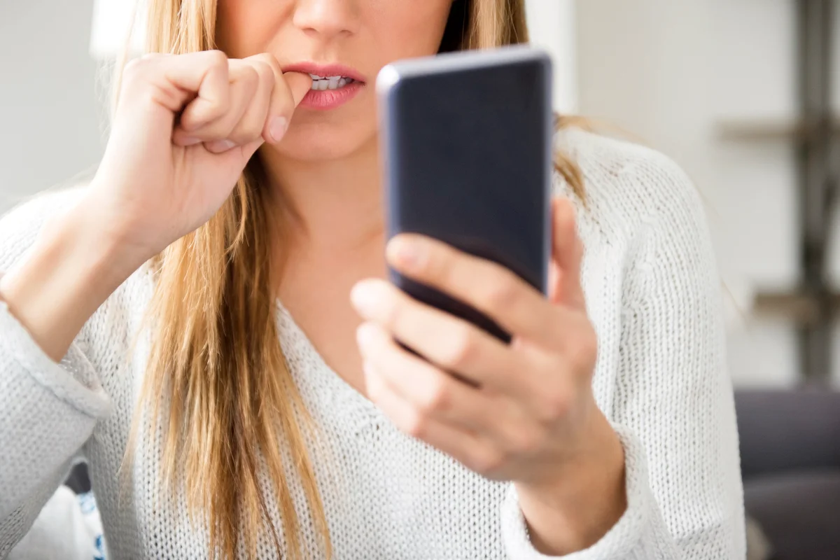 Nervous young woman using smart phone