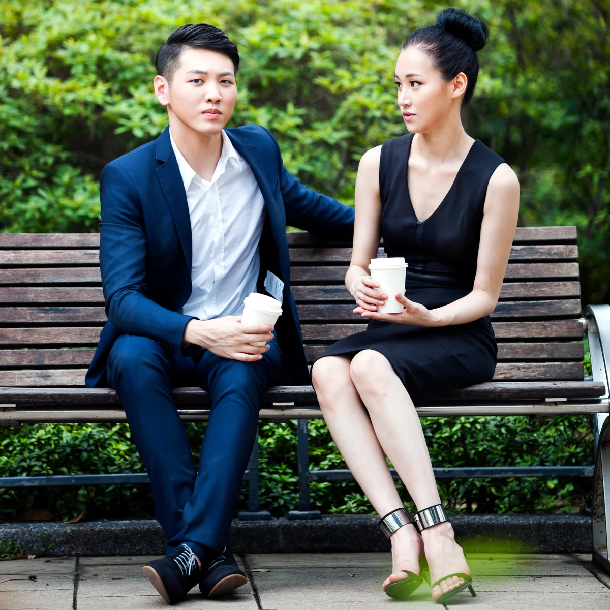 Two office colleagues having coffee in a park