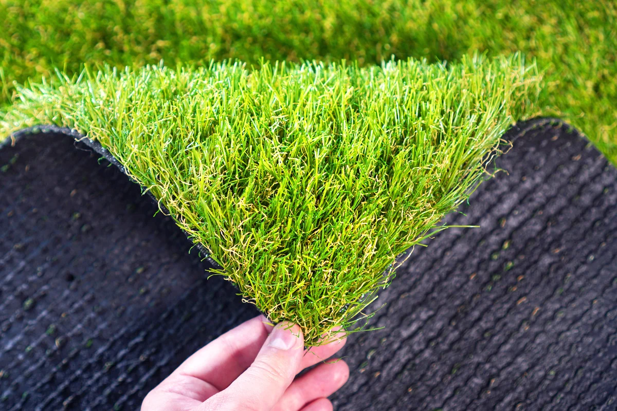 Hand holding an artificial grass roll