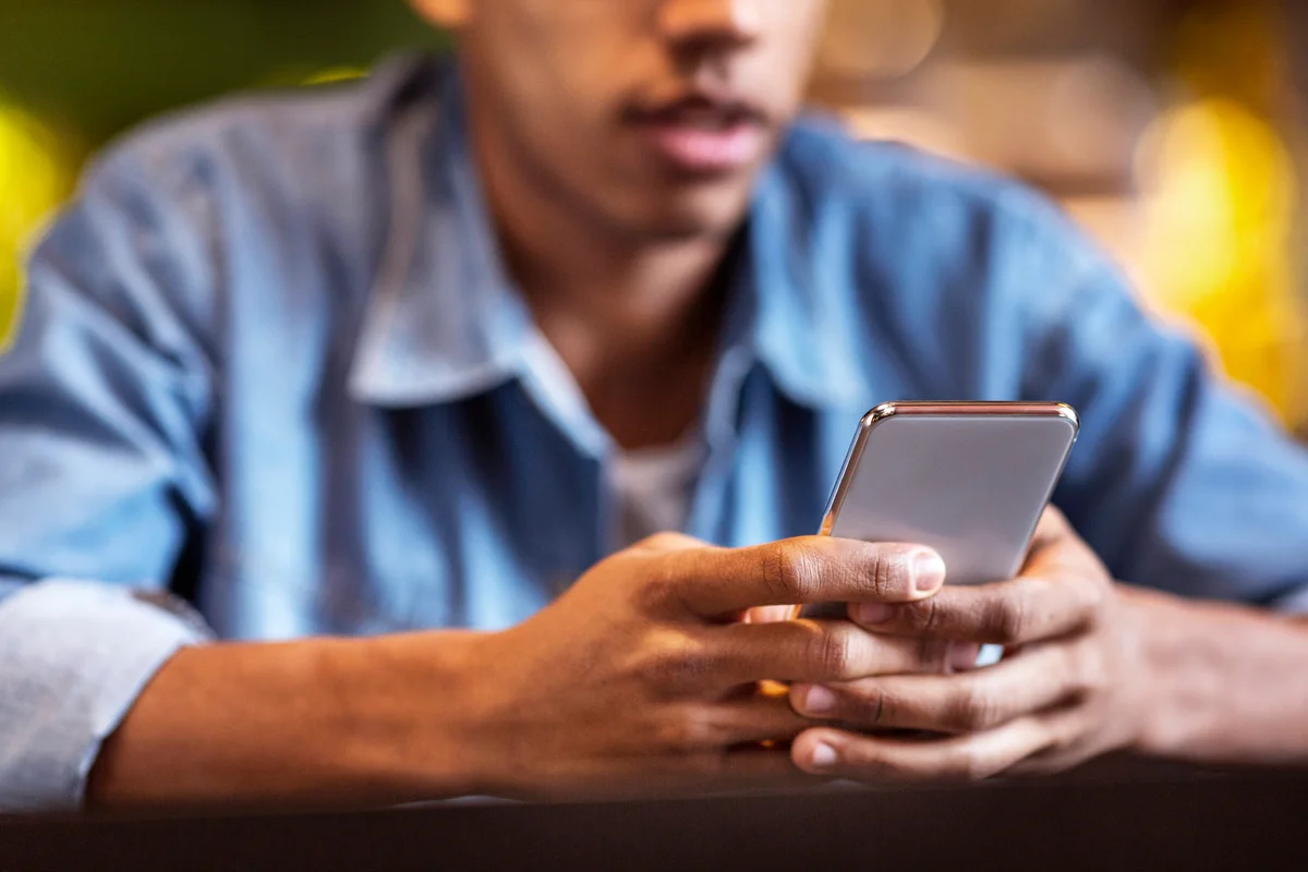 Teen texting at a cafe