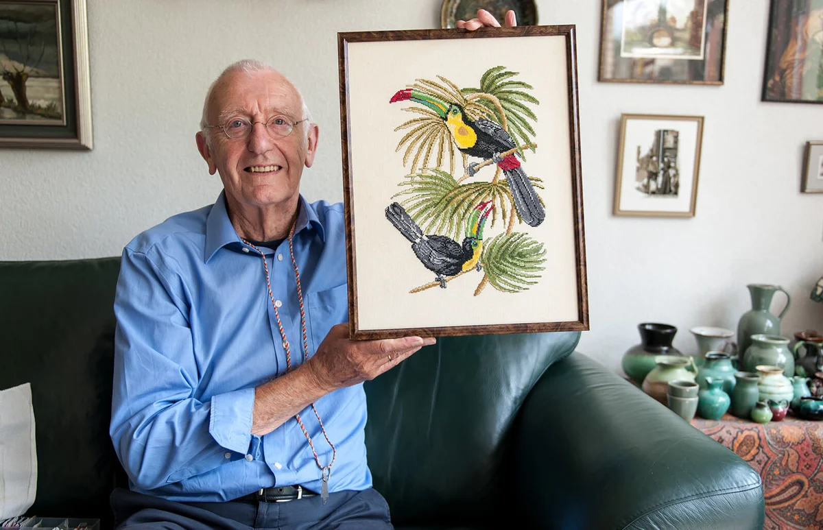 Senior man proudly showing his embroidered artwork