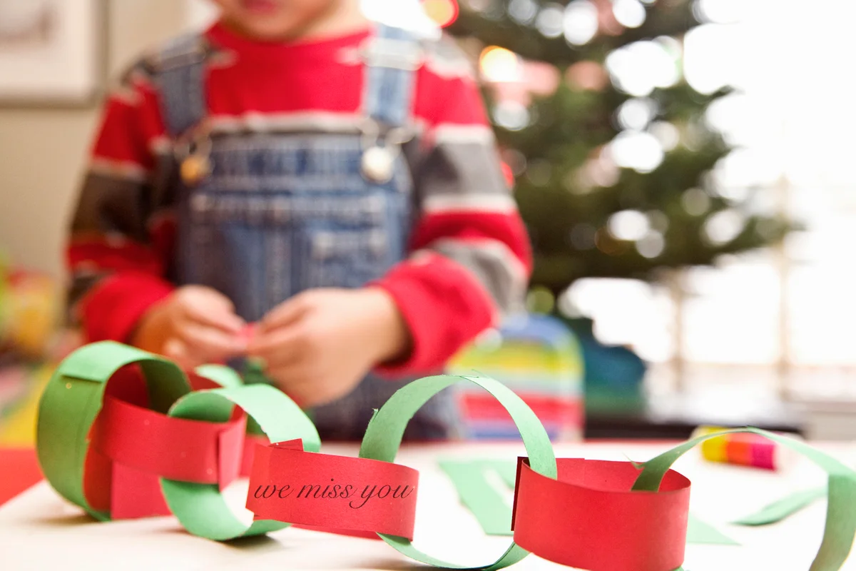 Boy making paper garland at christmas