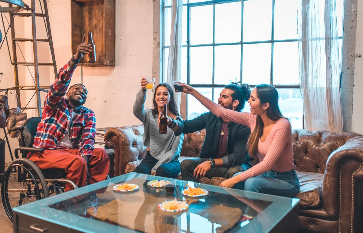 Smiling friends enjoying drinks in party at home