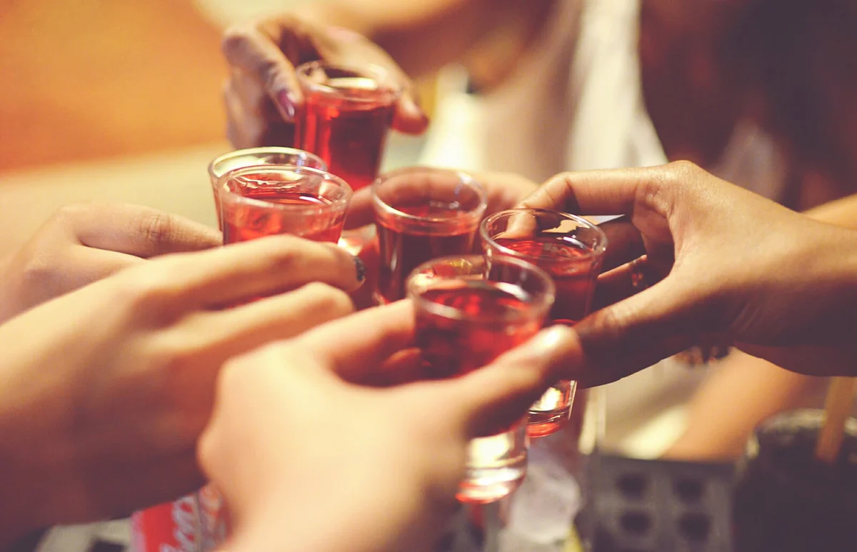 Friends toasting with pink whitney shot