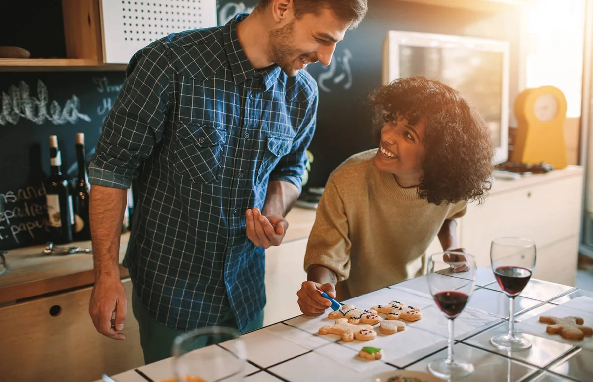 Cheerful couple making Christmas cookies together