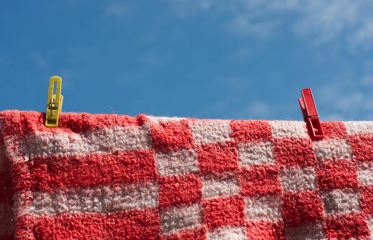 Laundry pins holding red fleecy blanket