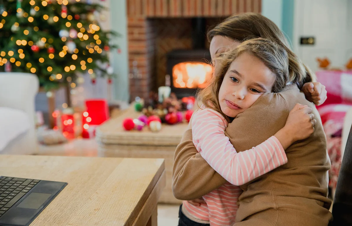 Sad little girl is cuddling with her mother at christmas time