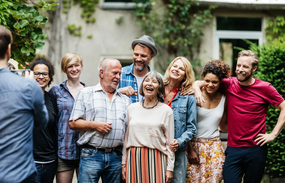 man taking a group photo with his family and friends