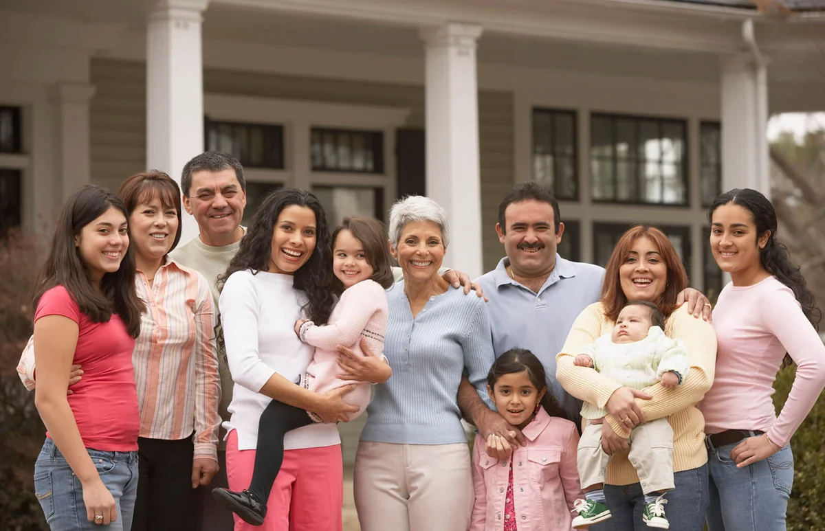 Large family standing in front of house