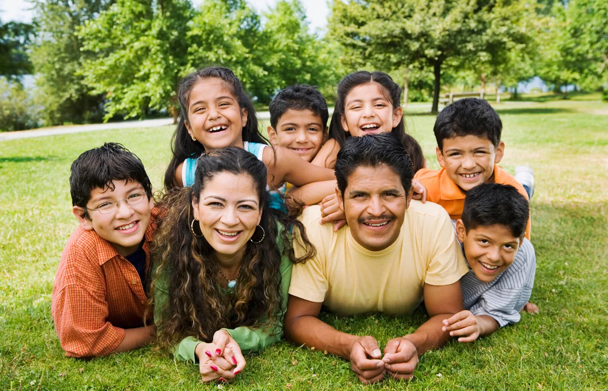 family laying grass smiling