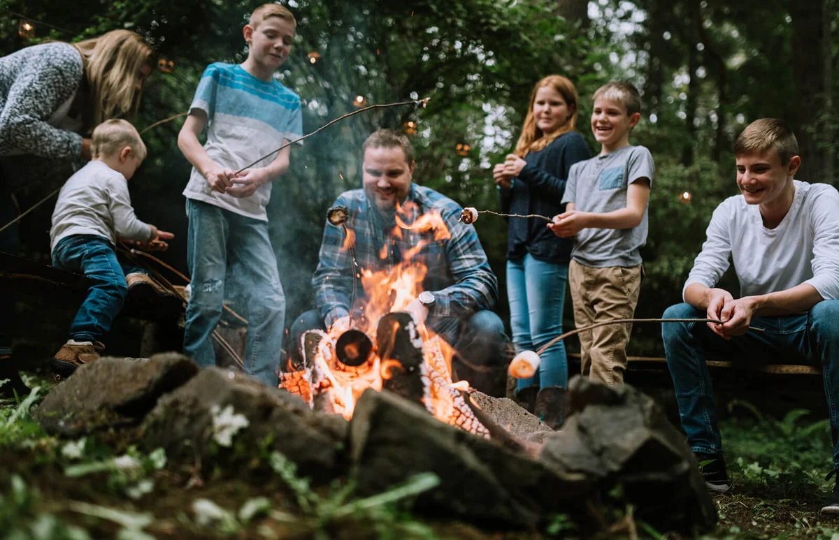 A young family enjoys relaxing by a fire