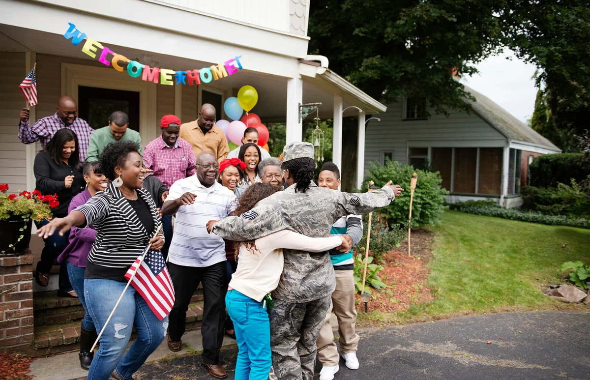 Female soldier embracing family and friends