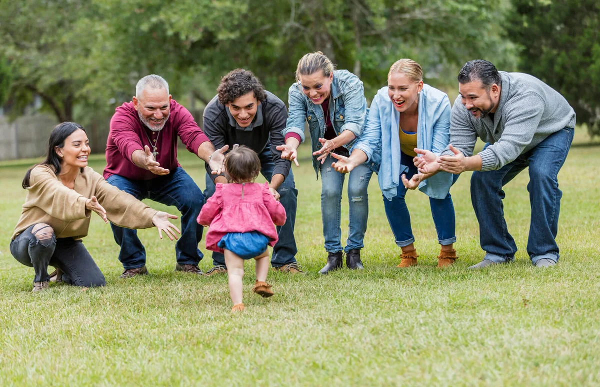 Multi-generation family, baby walking toward